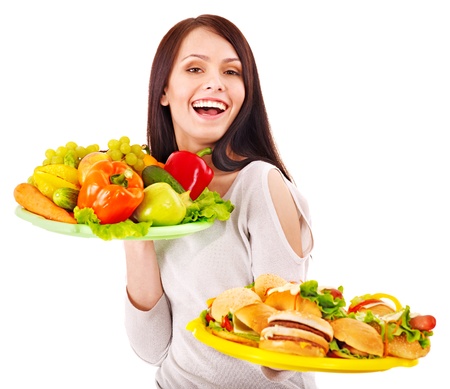 Woman choosing between fruit and hamburger. Isolated.の写真素材