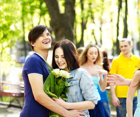 Couple  on date outdoor. Group of people in background.の写真素材