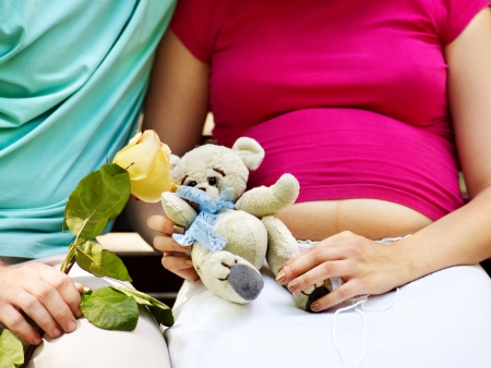 Pregnant woman, holding flower with man  outdoor in park.の写真素材