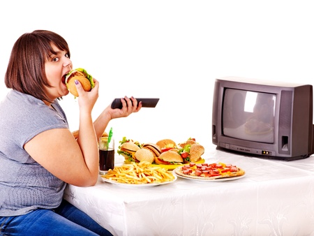 Big woman eating fast food and watching TV. Isolated.の写真素材