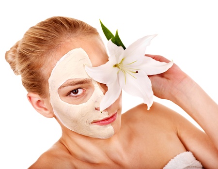 Woman  with facial mask  holding flower. Isolated.の写真素材