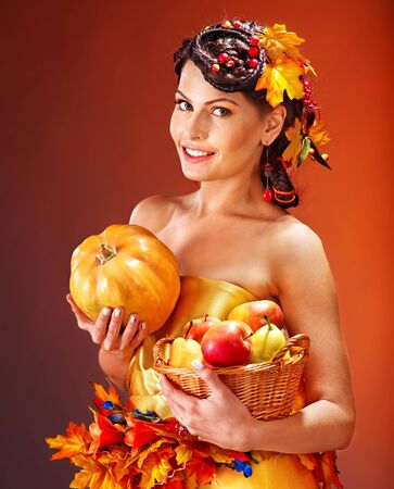 Woman holding autumn basket with fruit and vegetable.の写真素材