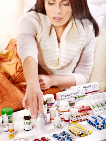 Woman with remedy having  flue in bed. Indoors.の写真素材