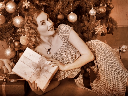 Woman receiving gifts under Christmas tree. Black and white retro.の写真素材
