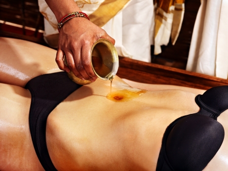 Young woman having stomach Ayurveda spa treatment.の写真素材