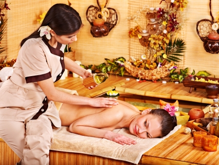 Young woman getting massage in bamboo spa.の写真素材