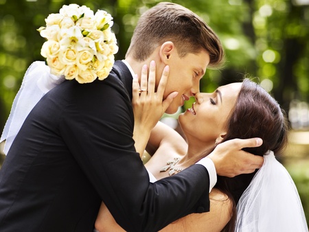 Bride and groom with flower kissing  outdoor.の写真素材