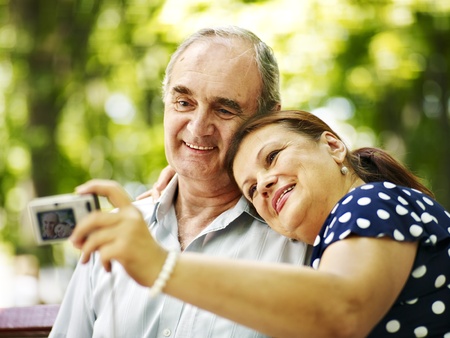 Happy old couple with camera take pictures.の写真素材