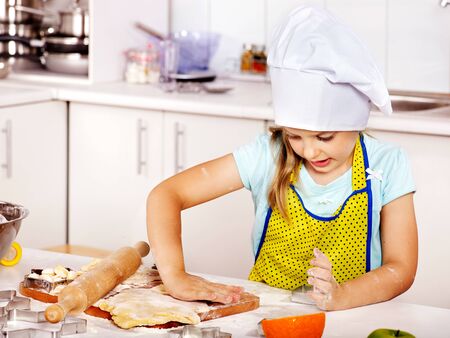 Child girl knead dough at kitchen.の写真素材