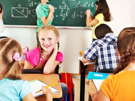 Teen school child sitting on desk in classroom.の写真素材