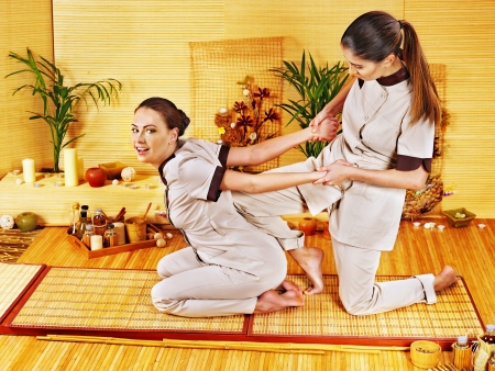 Therapist giving Thai stretching massage to woman.の写真素材