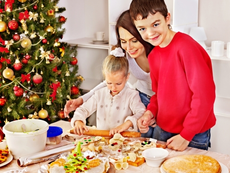 Happy family with children rolling dough in Christmas kitchenの写真素材
