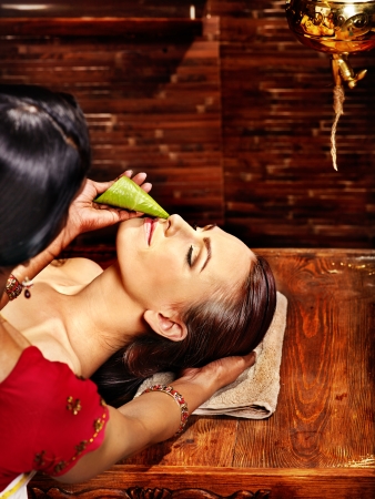 Woman having nose ayurveda spa treatment.の写真素材