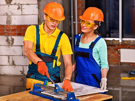 Happy group people builder cutting ceramic tile の写真素材