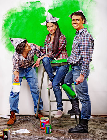 Happy group people paint wall at home.の写真素材