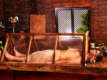 Man having Ayurvedic sauna treatment の写真素材