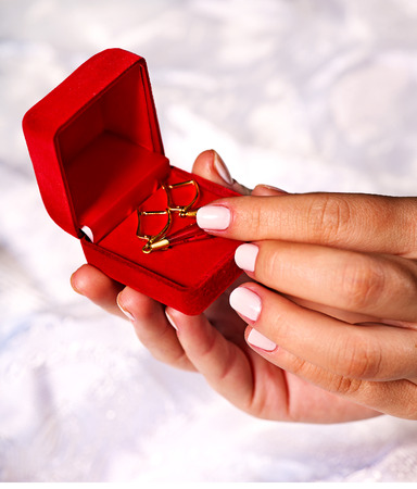 Female hand holding jewelry box with earrings.Wedding background.の写真素材