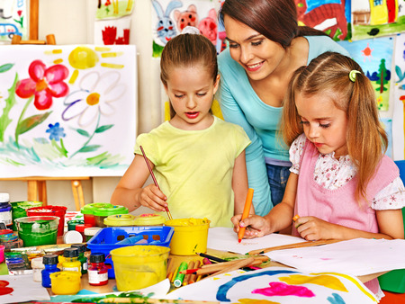 Happy children  with teacher painting.の写真素材