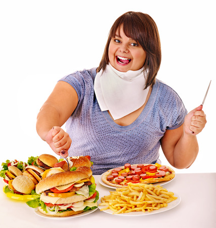 Overweight woman eating fast food.の写真素材