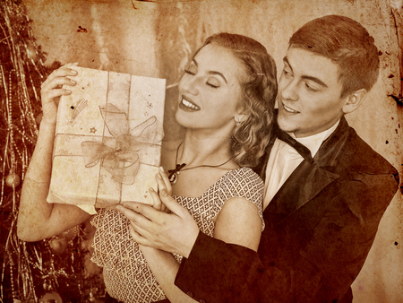 Couple on party near Christmas tree. Sepia toned.の写真素材