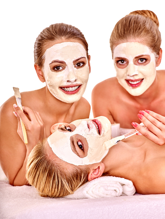 Group woman getting facial mask and gossip . Isolated. Three smiling girls.の写真素材