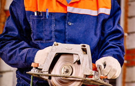 Hands of man  builder holding circular saw.の写真素材
