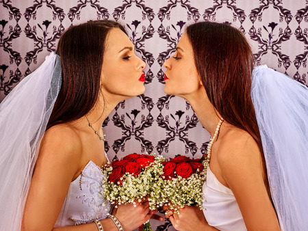 Wedding lesbians girl in bridal dress kissing. Indoor.の写真素材