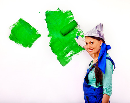 Happy woman painting  wall on green at home.の写真素材