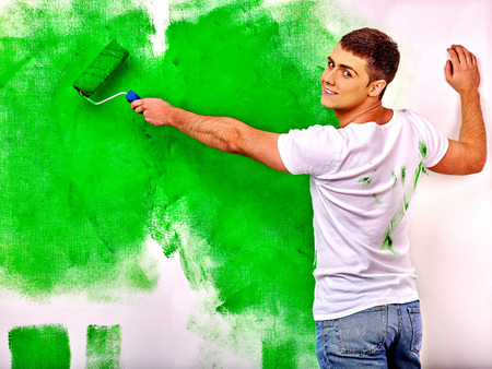 Happy man paint wall at home.の写真素材