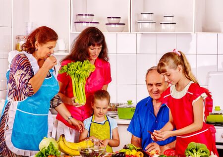 Happy family with child cooking at kitchen. Grandfather and grandmother.
