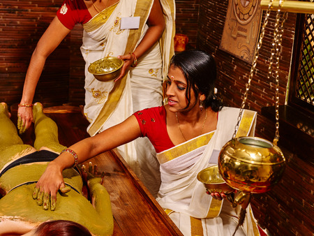 Young woman having body Ayurveda spa massage. Two therapist.の写真素材