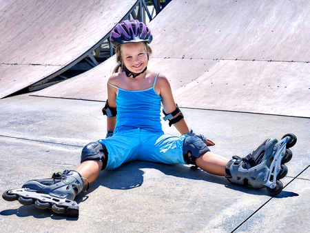 Girl in roller skates sitting on ride in skatepark.の写真素材