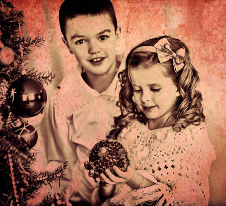 Children sister and brother decorate on Christmas tree. Black and white retro.の写真素材