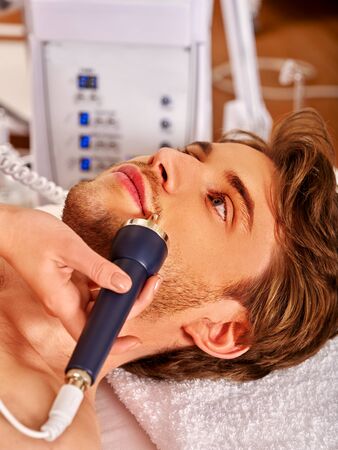 Man receiving electric facial peeling at beauty salon.の写真素材