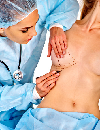 Augmentation breast cancer surgery. Female doctor makes dotted line on female body on isolated.の写真素材