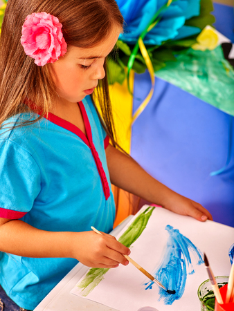 Beauty little girl with brush painting on table in  kindergarten .の写真素材