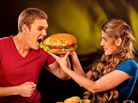 Woman feeds man fast food. Concept.の写真素材