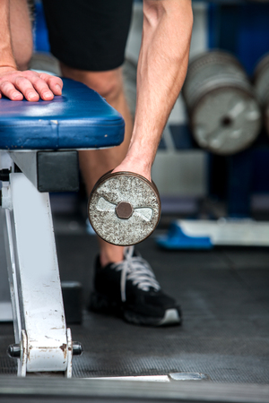 Male body part with  dumbbells working his arms at gym. Close up of hands.の写真素材