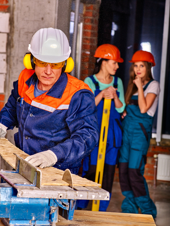 group people  builder hard working with circular saw.