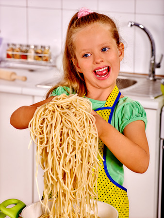Children  eating spaghetti at kitchen. Kid cooking concept.の写真素材