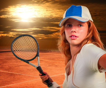 Girl in cap holding tennis  racket on sun sky with clouds.の写真素材