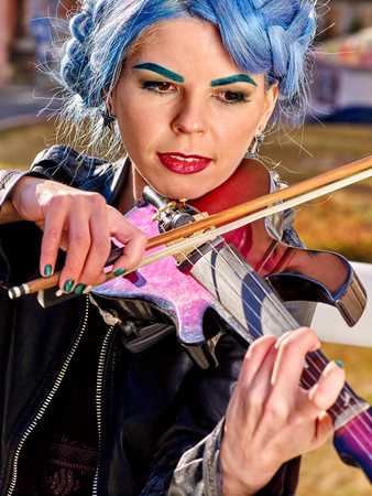 Portrait of music street performers girl violinist with blue hair playing  outdoor.の写真素材