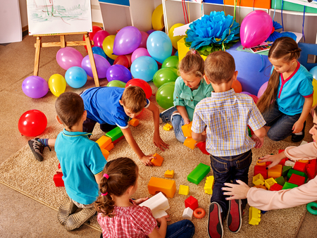 Group children game blocks on floor in kindergarten . Balloons on floor Top view.の写真素材