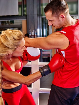 Couple man and girl  wearing gloves boxing in ring. Girl sideswipe man.の写真素材