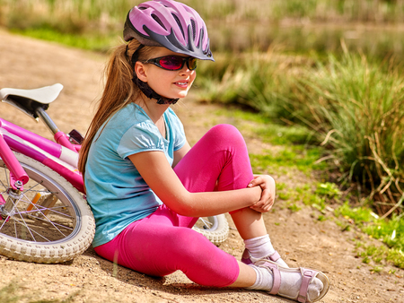 Bikes bicycle child . Happy child sitting on road near bicycles. Cycle racing concept. Child wearing bicycle helmet.の写真素材