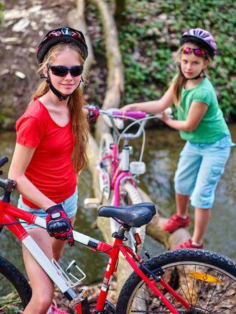 Bikes cycling girl. Girl rides bicycle. Girl cycling fording throught water on log. Cycling trip is good for health. Cyclist watch your step.の写真素材
