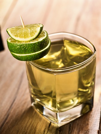 Healthy drink. On wooden boards is glass with green transparent drink. A drink number hundred and two cold green tea decoration lime. Country life. Light background.の写真素材