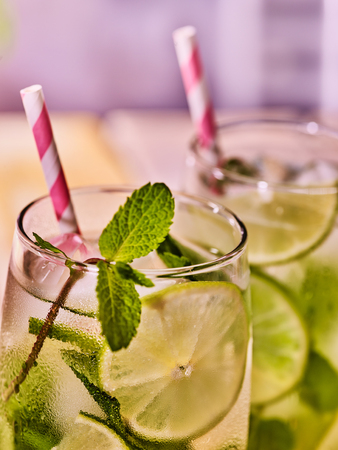 Alcohol drink. Part of two glasses with alcohol cocktail drink and ice cubes. Drink number hundred twelve cocktail mohito with straw. Country life. Light background.Close up.の写真素材