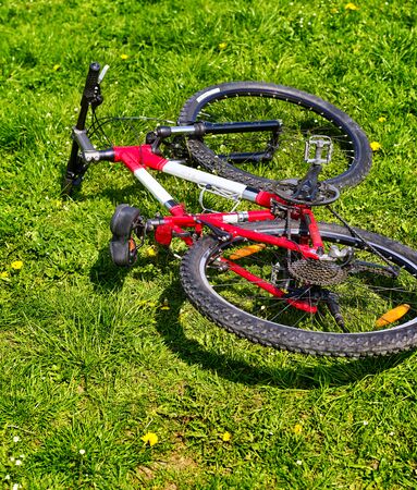 City bicycle lying on green grass . No people. Bicycle concept