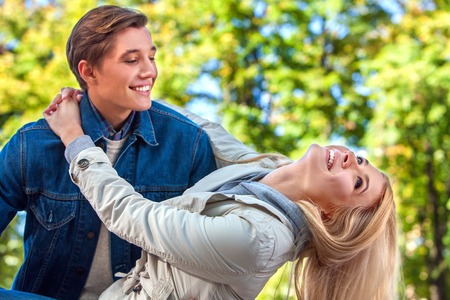 Young couple in love dancing and flirting in park. Good weather in fall park for couple in love.